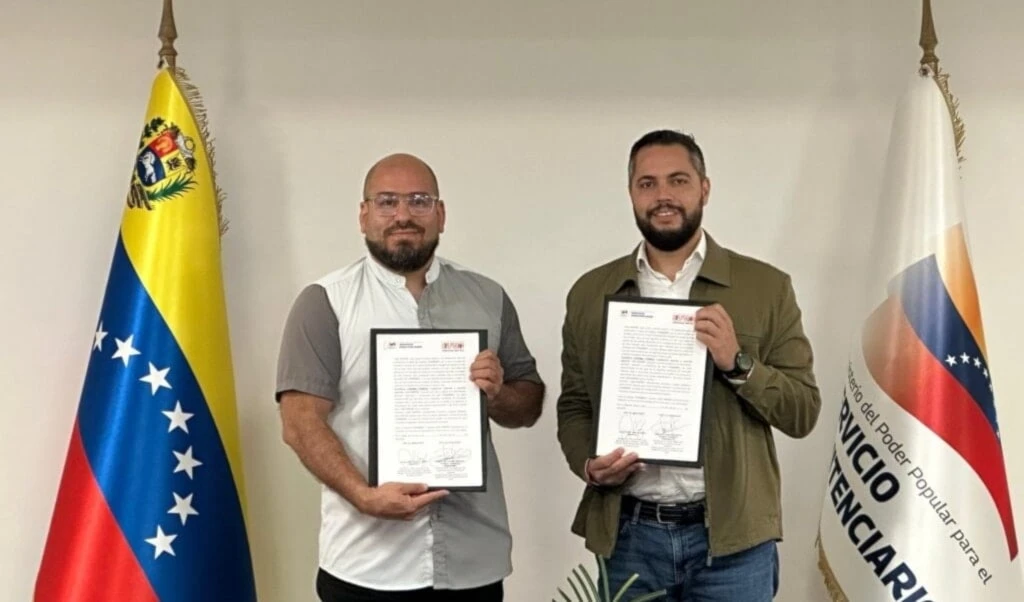 De izquierda a derecha, Omar Rangel, presidente de la Fundación Librerías del Sur, y Julio García Zerpa, ministro para el Servicio Penitenciario, firmando un acuerdo de bibliotecas en centros penitenciarios.