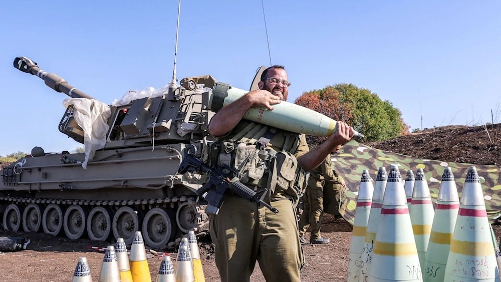 Un soldado israelí traslada un proyectil de artillería de 155 mm cerca de la frontera libanesa (Foto:AFP).