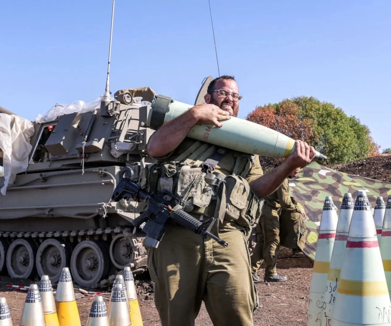 Un soldado israelí traslada un proyectil de artillería de 155 mm cerca de la frontera libanesa (Foto:AFP).