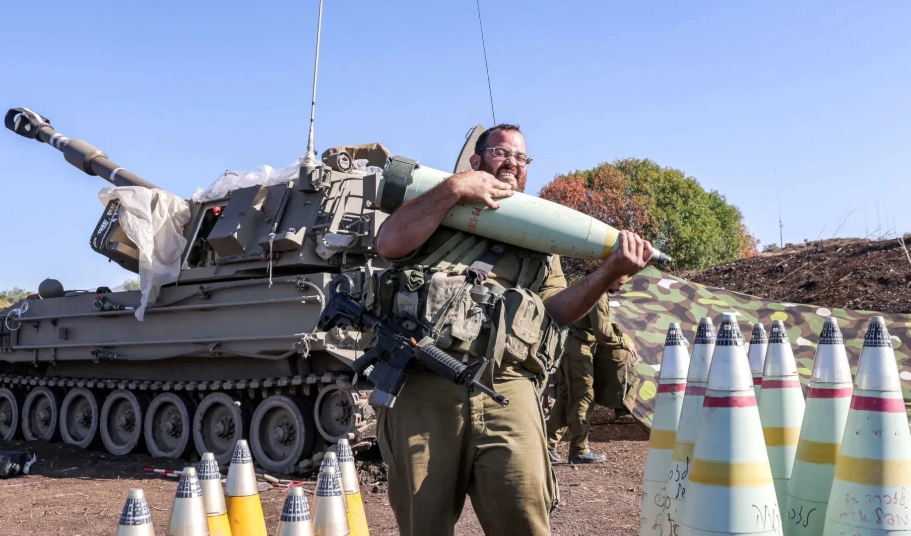 Un soldado israelí traslada un proyectil de artillería de 155 mm cerca de la frontera libanesa (Foto:AFP).