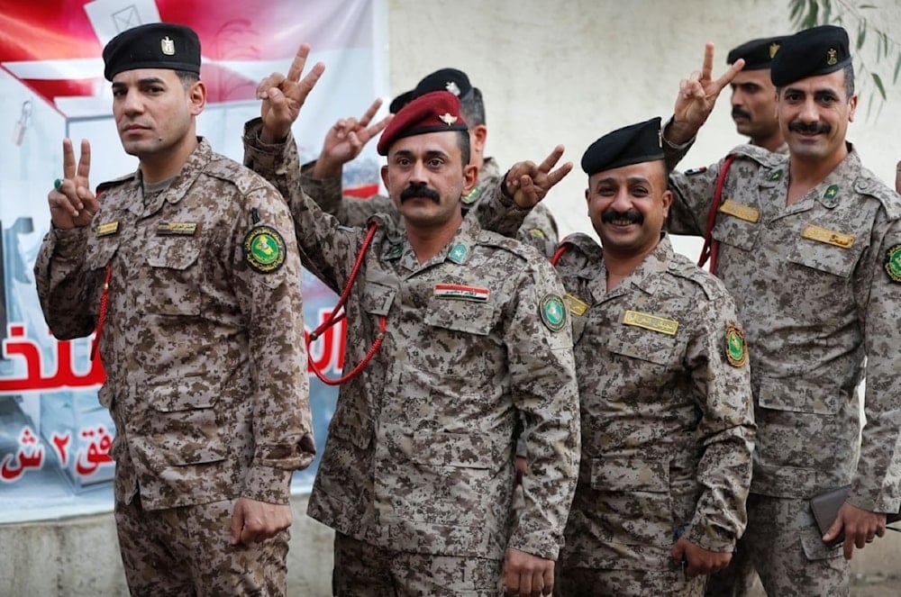 Soldados iraquíes muestran signo de la victoria antes de emitir sus votos en un colegio electoral en Bagdad (Foto: AFP)