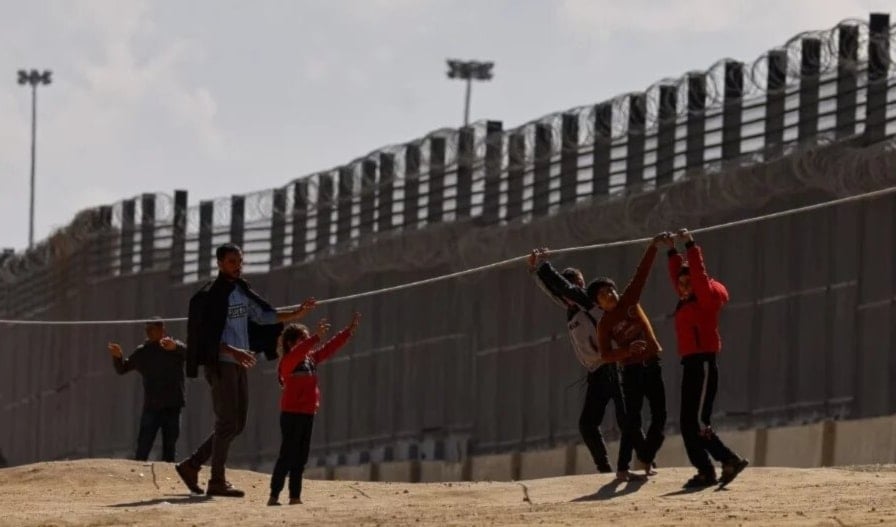 Niños palestinos juegan en la frontera con Egipto, en la ciudad de Rafah. 15 de febrero de 2024 (Foto: Reuters)