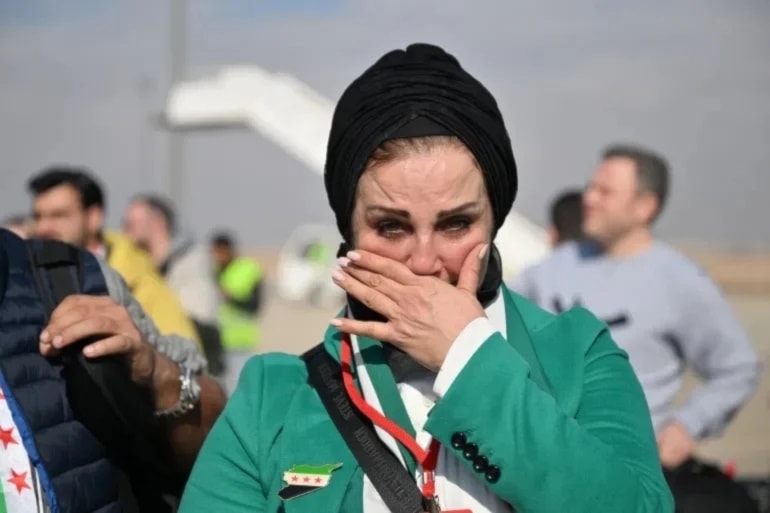 Mujer siria llora por la alegría de regresar a su país.