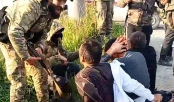 Jóvenes alauitas arrodillados en el suelo mientras recibían insultos y golpizas por parte de los agentes de seguridad.