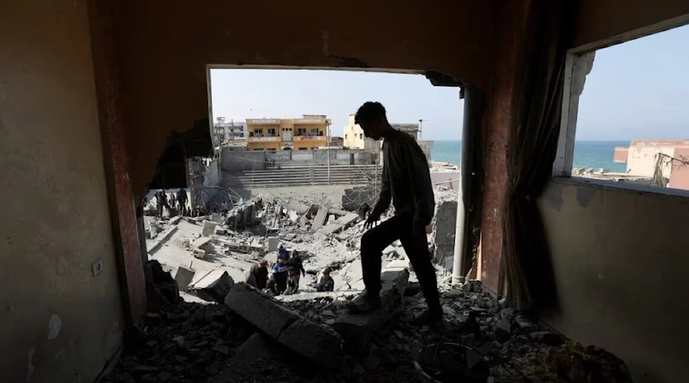 Palestinos inspeccionan el lugar de un ataque aéreo israelí contra un edificio residencial en Deir al-Balah, centro de Gaza (Foto: Reuters)