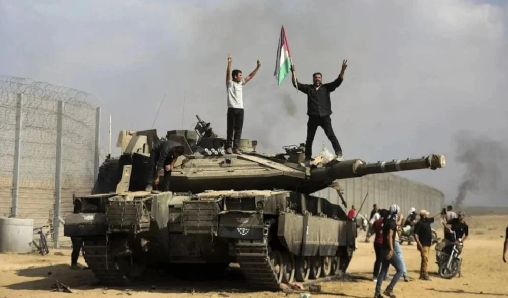 Palestinos celebran sobre un tanque enemigo los éxitos del 7 de octubre de 2023.