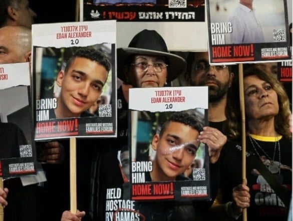 Manifestantes portan imágenes del exprisionero israelí-estadounidense Edan Alexander.