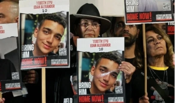 Manifestantes portan imágenes del exprisionero israelí-estadounidense Edan Alexander.