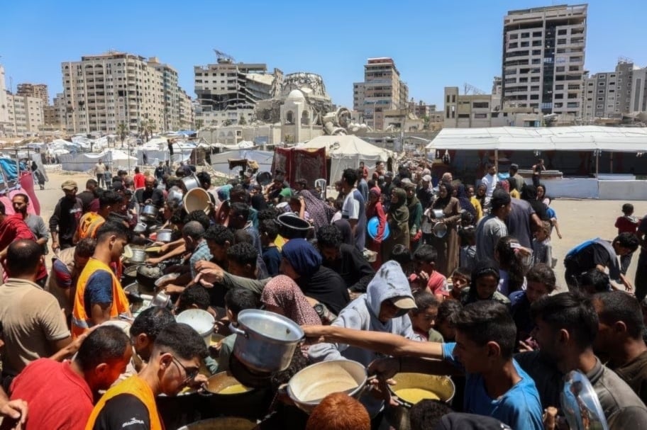 Palestinos esperan comidas en un punto de distribución de alimentos en la ciudad de Gaza. 21 de mayo de 2025. (Foto: AFP)