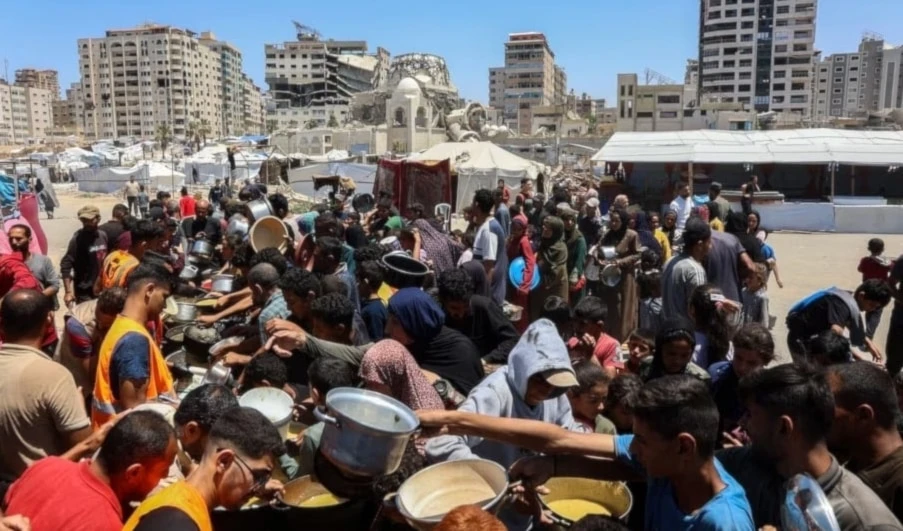 Palestinos esperan comidas en un punto de distribución de alimentos en la ciudad de Gaza. 21 de mayo de 2025. (Foto: AFP)