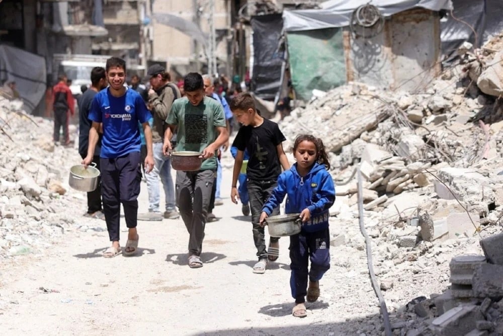 Niños de Gaza reciben alimentos en Jabalia, mientras empeora la crisis del hambre porque 
