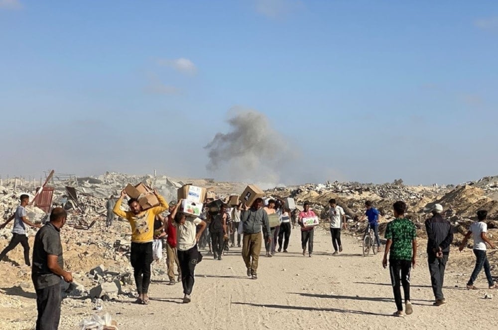 Palestinos desplazados en Rafah reciben paquetes de alimentos en medio de una crisis humanitaria asfixiante. 