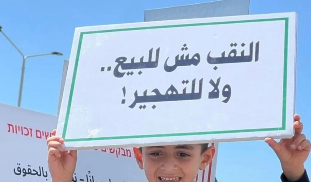 Niño palestino sostiene un cartel que dice: El Negev no está en venta.