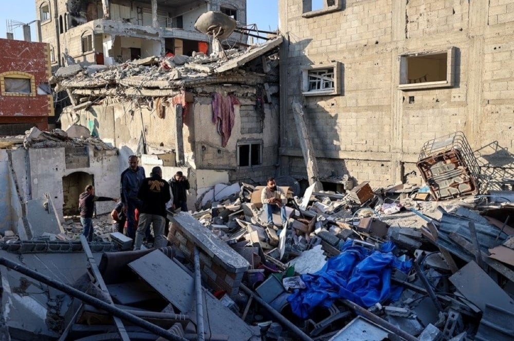 Palestinos buscan sobrevivientes entre los escombros de un edificio destruido por un ataque israelí en Gaza. 