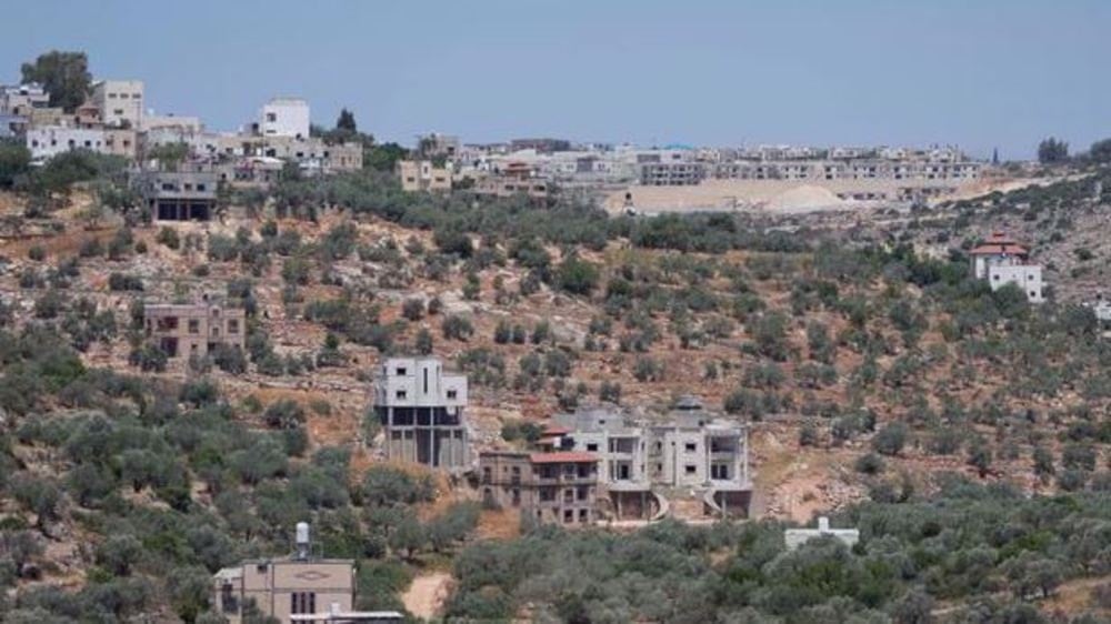 El asentamiento israelí de Bruchin (centro), en la cima de una colina y adyacente a la aldea cisjordana de Bruqin. Foto AP