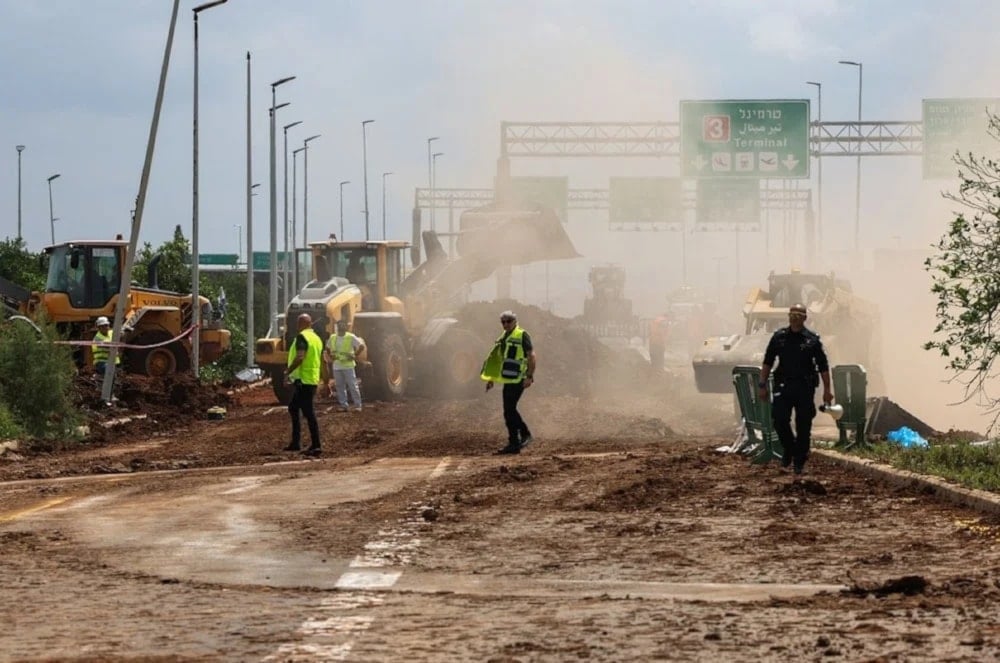 Equipos de emergencia israelíes evacuan una carretera fuera del aeropuerto Ben Gurion tras la caída del misil yemenita. (Foto: AFP)