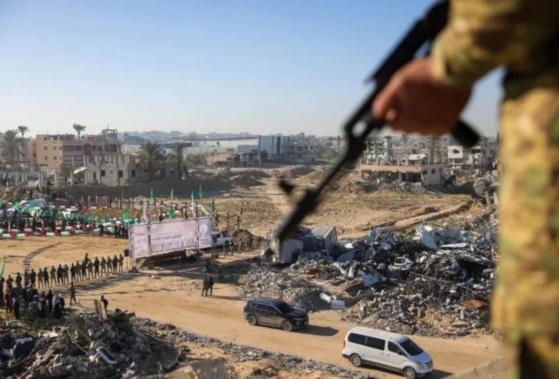 Un miembro de Hamas observa desde lo alto de un edificio la entrega de prisioneros israelíes al equipo de la Cruz Roja en Khan Yunis - 15 de febrero de 2025 (Getty Images)