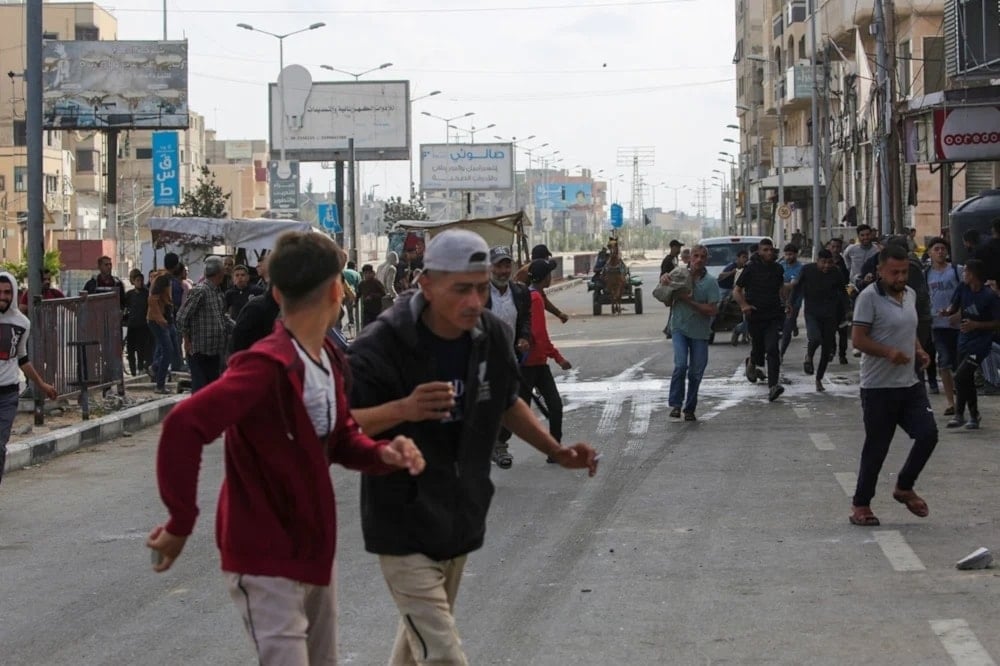 Palestinos se alejan de un punto de distribución de ayuda cerca del puesto de control de Netzarim, en el centro de la Franja de Gaza.