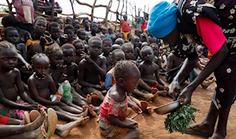Sirven hojas silvestres hervidas como alimento a niños huérfanos en el campo de desplazados internos de Bruam, al sur de Sudán.