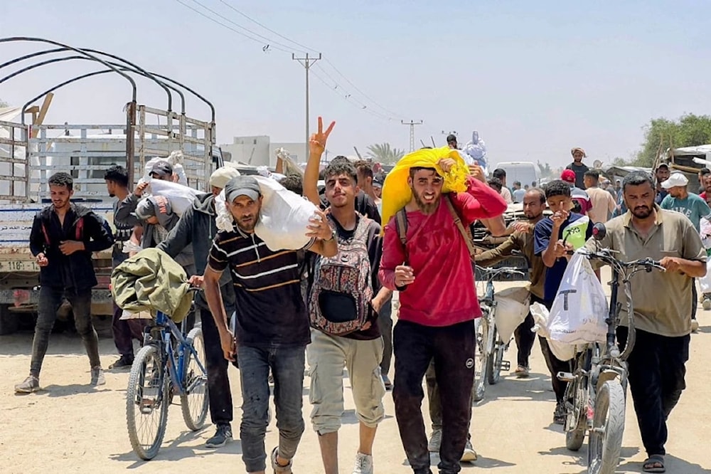 Palestinos desplazados reciben ayuda humanitaria en Rafah, al sur de la Franja de Gaza. Foto: AFP