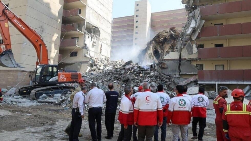 Voluntarios de la Media Luna Roja iraní frente aun edificio bombardeo por 