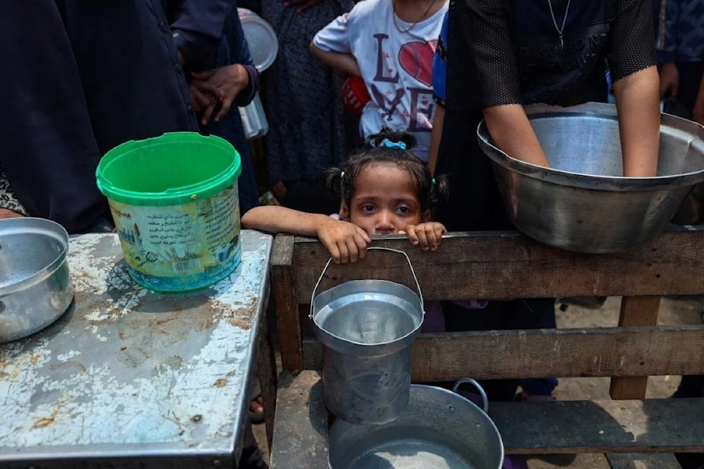 Un niño espera comida en el centro de distribución de ayuda de Nuseirat, en el centro de la Franja de Gaza.