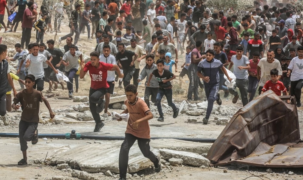 Palestinos corren en busca de ayuda humanitaria en la Franja de Gaza.