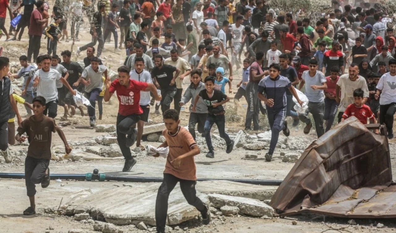 Palestinos corren en busca de ayuda humanitaria en la Franja de Gaza. Palestinos corren en busca de ayuda humanitaria en la Franja de Gaza.