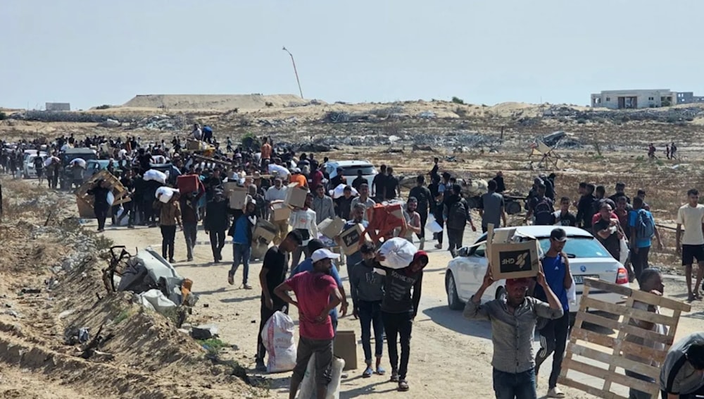 Palestinos llevan ayuda de la Fundación Humanitaria de Gaza después de esperar durante horas y ser baleados por francotiradores israelíes.