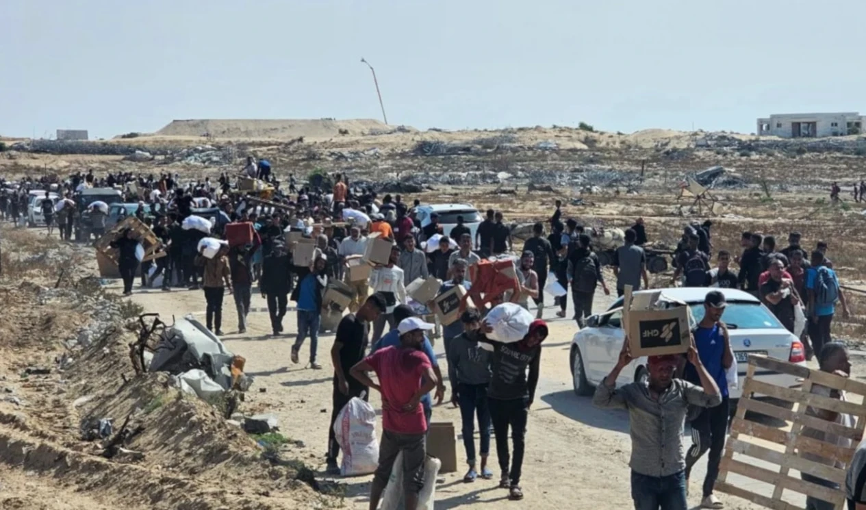 Palestinos llevan ayuda de la Fundación Humanitaria de Gaza después de esperar durante horas y ser baleados por francotiradores israelíes.