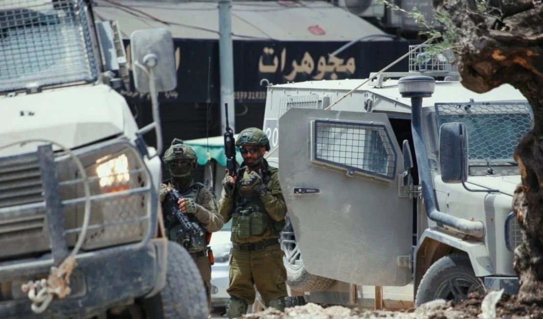 Soldados israelíes apostados cerca de los vehículos blindados en el centro de Yenín.