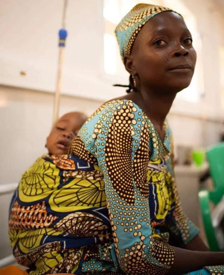 La bebé Jamila está siendo tratada por desnutrición en el centro de alimentación terapéutica de la ciudad de Katsina, mientras su madre, Rabi, la cuida. Foto: Zoe Bennell/MSF.