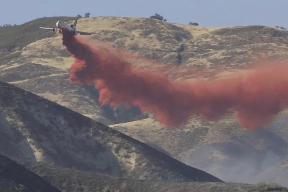 Avioneta tirando material retardante contra el fuego. Foto: AP. 