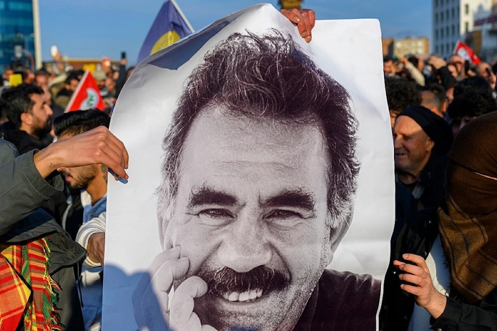 Manifestantes sostienen foto del líder opositor kurdo.