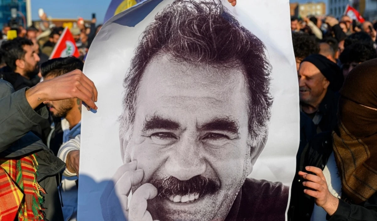 Manifestantes sostienen foto del líder opositor kurdo.