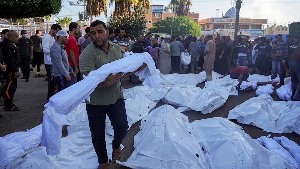 Un palestino lleva el cuerpo de un mártir asesinado en la agresión israelí a Gaza.