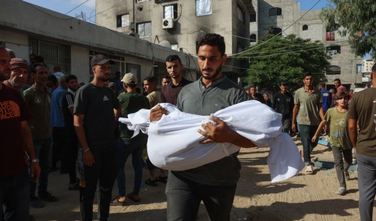 Palestino carga en sus brazos el cuerpo de su hijo mártir por los bombardeos israelíes. (Foto: AFP)